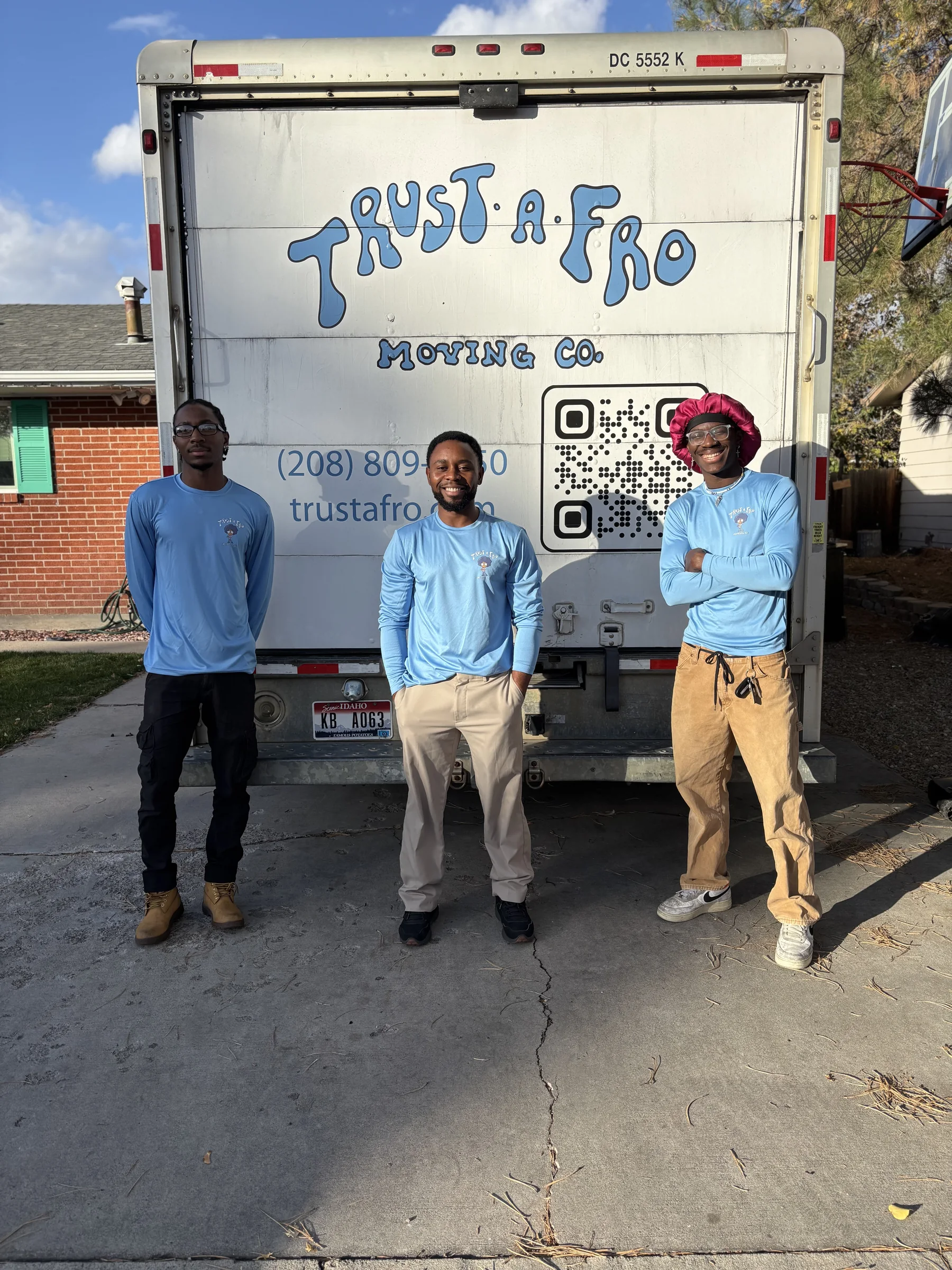 Three Trust A Fro movers standing in front of the branded moving truck